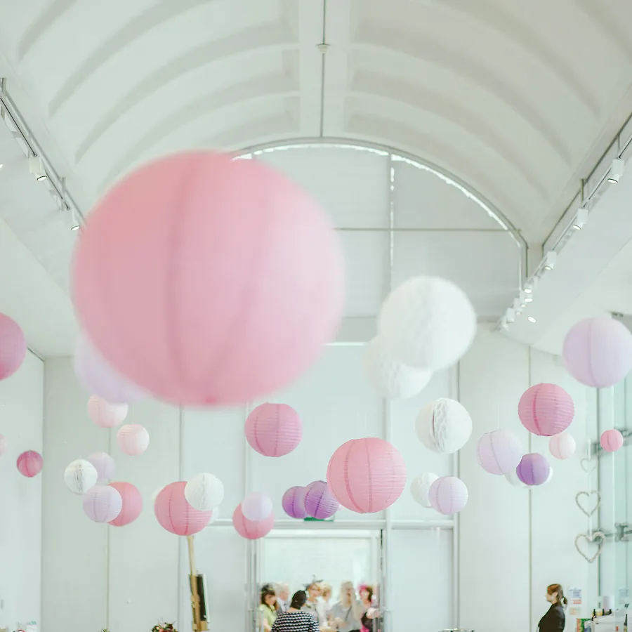 Pink and white paper lanterns hanging in a hall