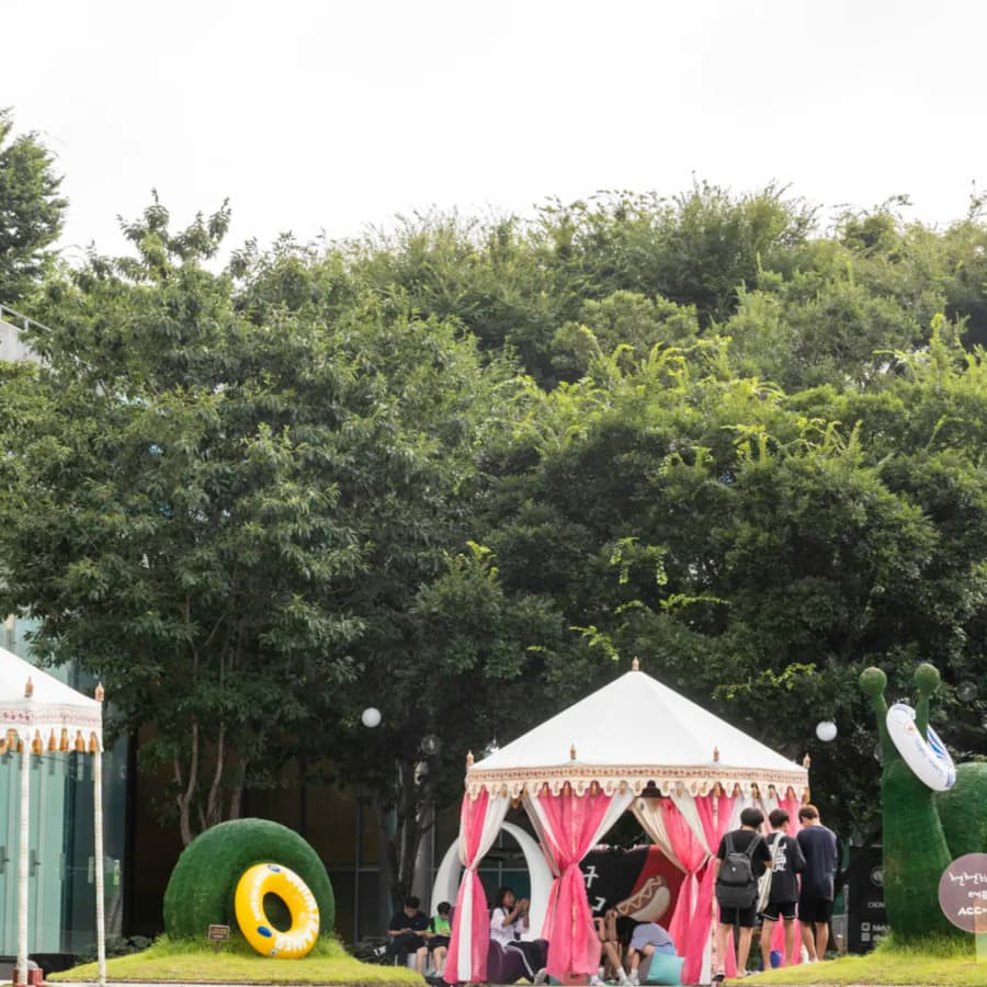 Pink and white striped tent on a lawn at an outdoor event