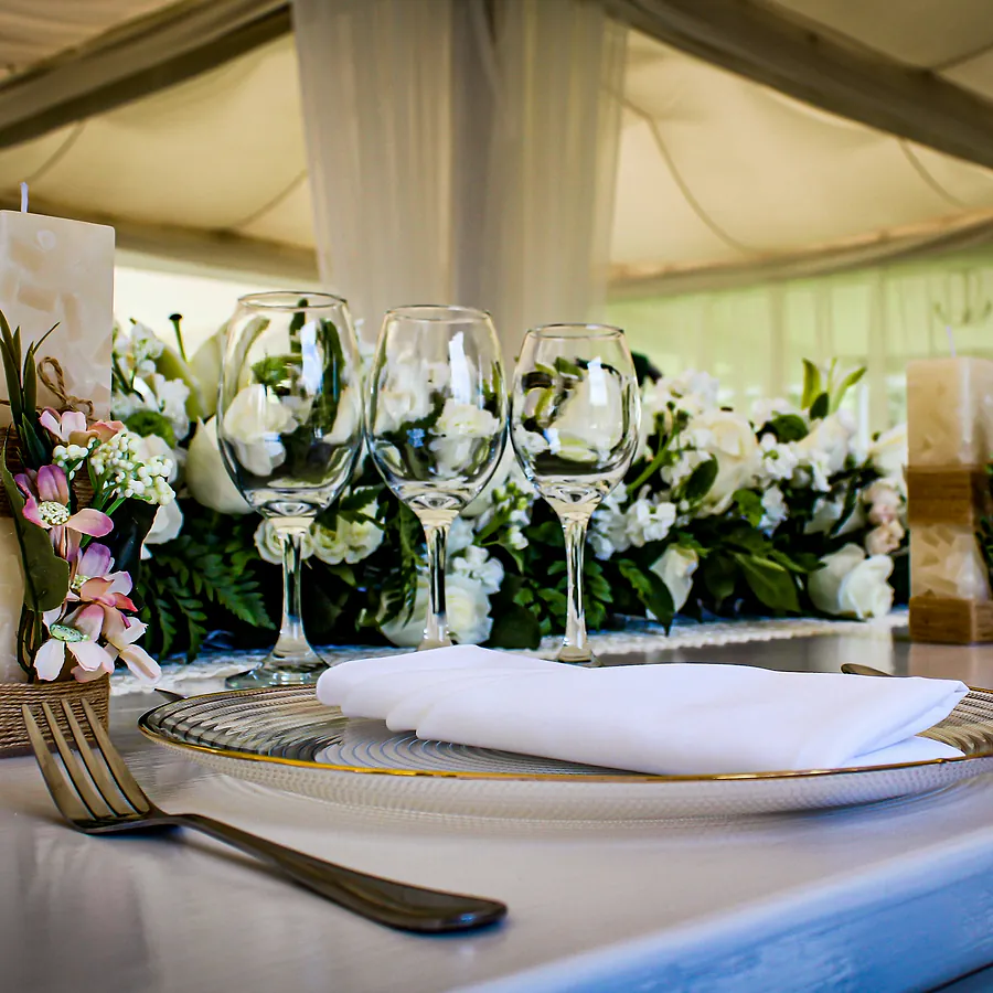 Formal place setting with white florals in a marquee