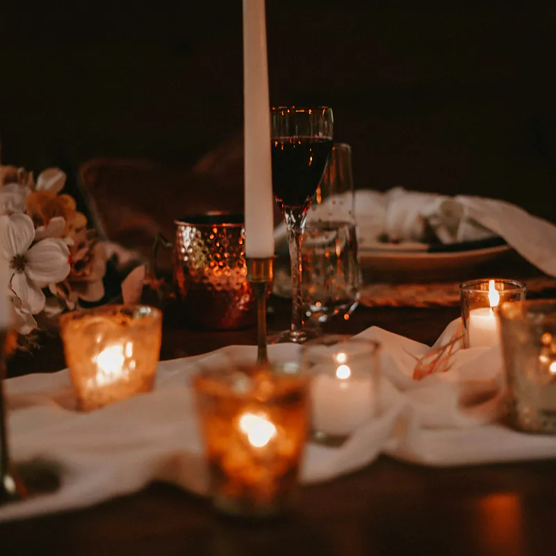 Candles and glassware on a dressed dinner table